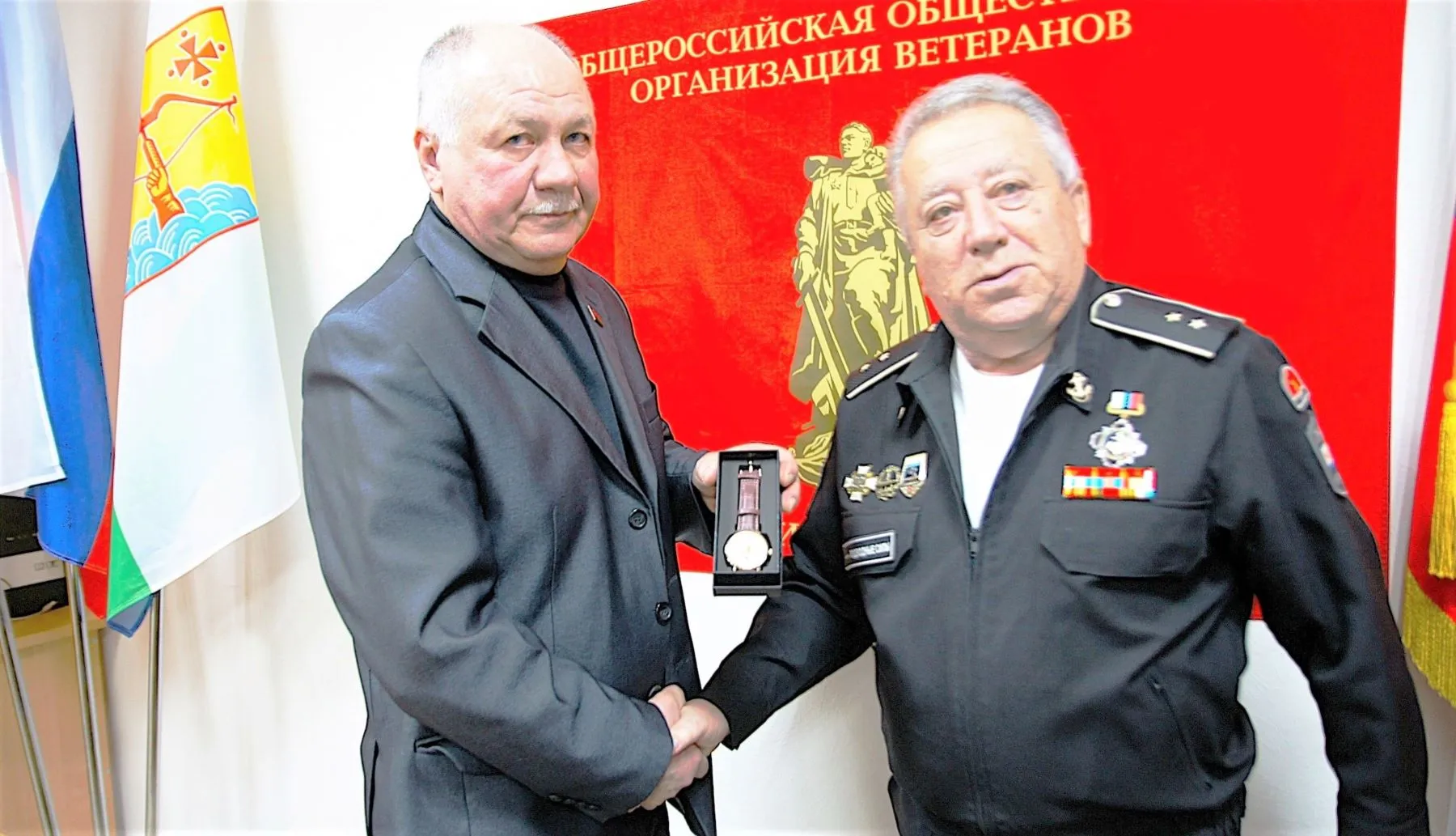 На снимке: член Правления Российского фонда ветеранов капитан 1 ранга в отставке Анатолий Свирякин вручает ценный подарок – наручные часы с символикой Российского фонда ветеранов мичману в отставке Александру Цырульникову.